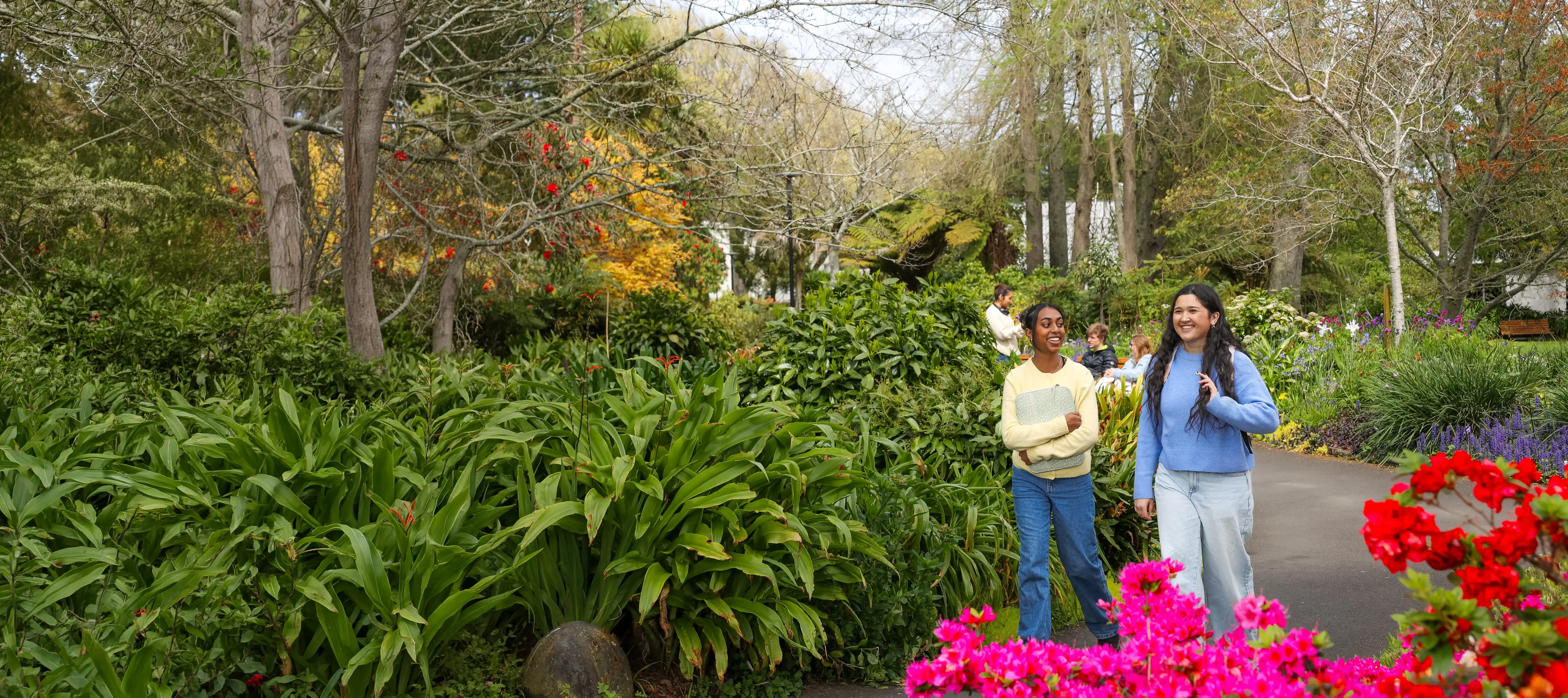 two-students-walking-through-garden