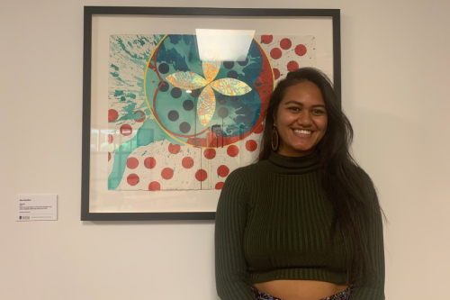 Maia Gardiner standing infront of a picture. 