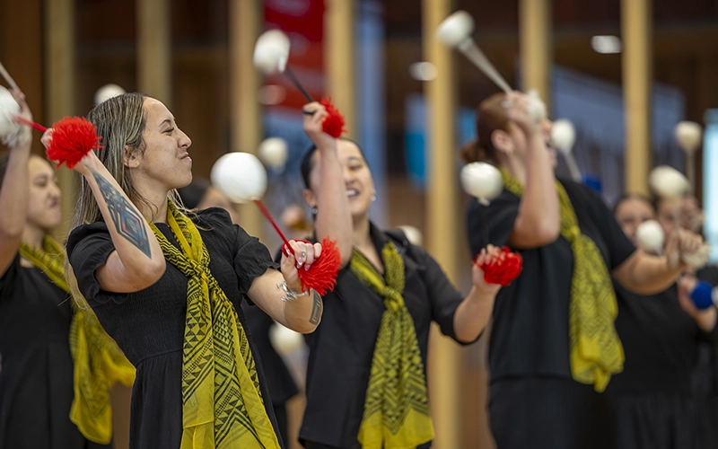 A kapa haka group perform with poi at a Māori and Pacific expo day