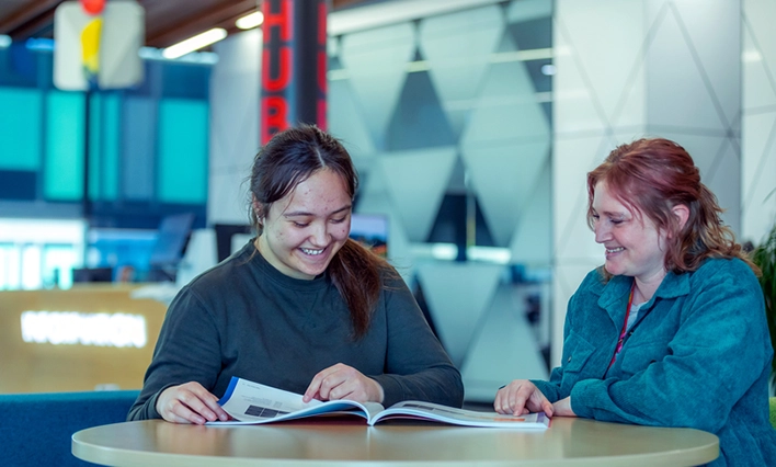 Tauranga student and staff reading a booklet