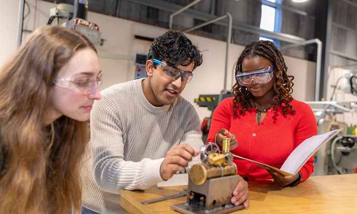 Three engineering students working in a lab