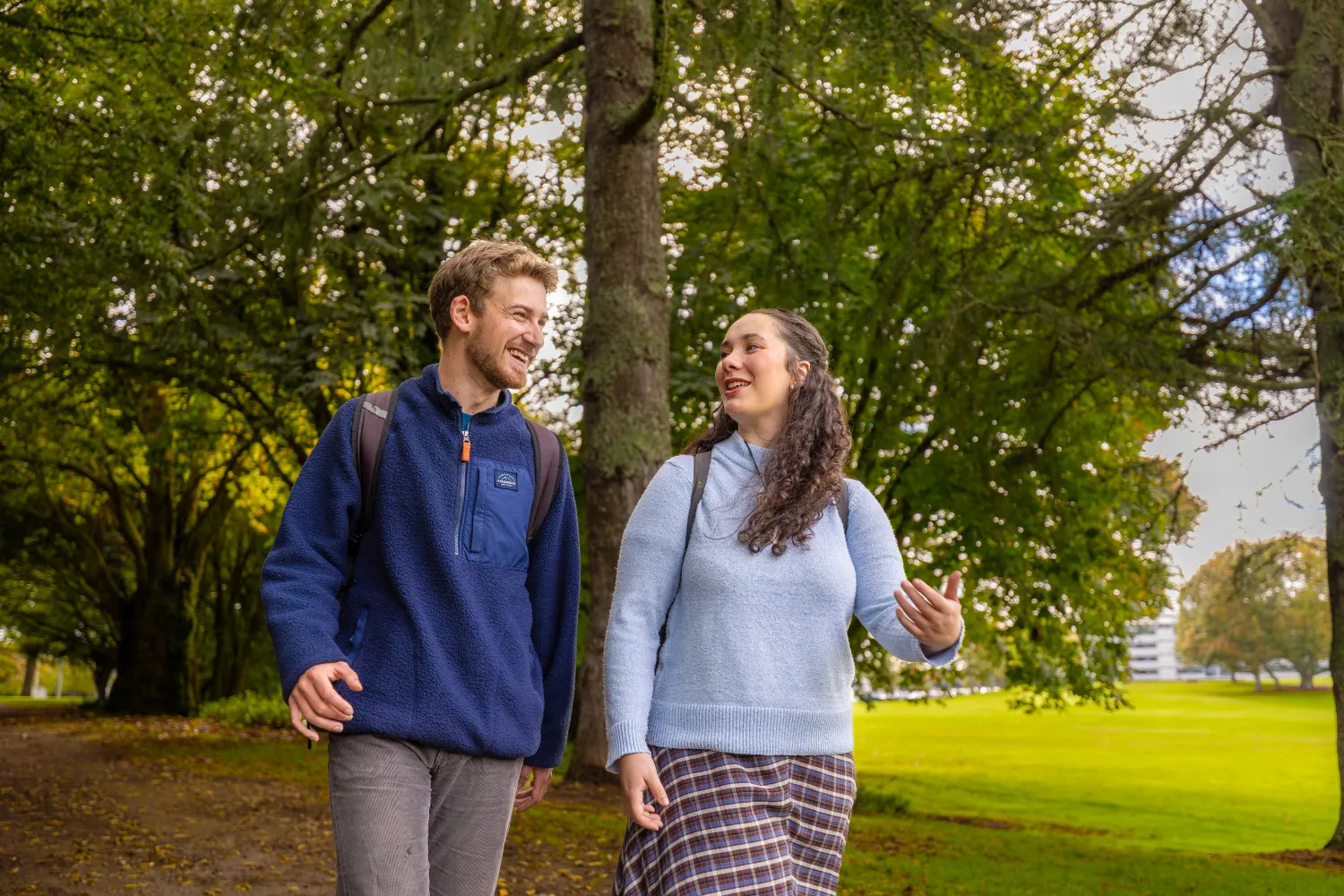 two-students-walking-through-trees