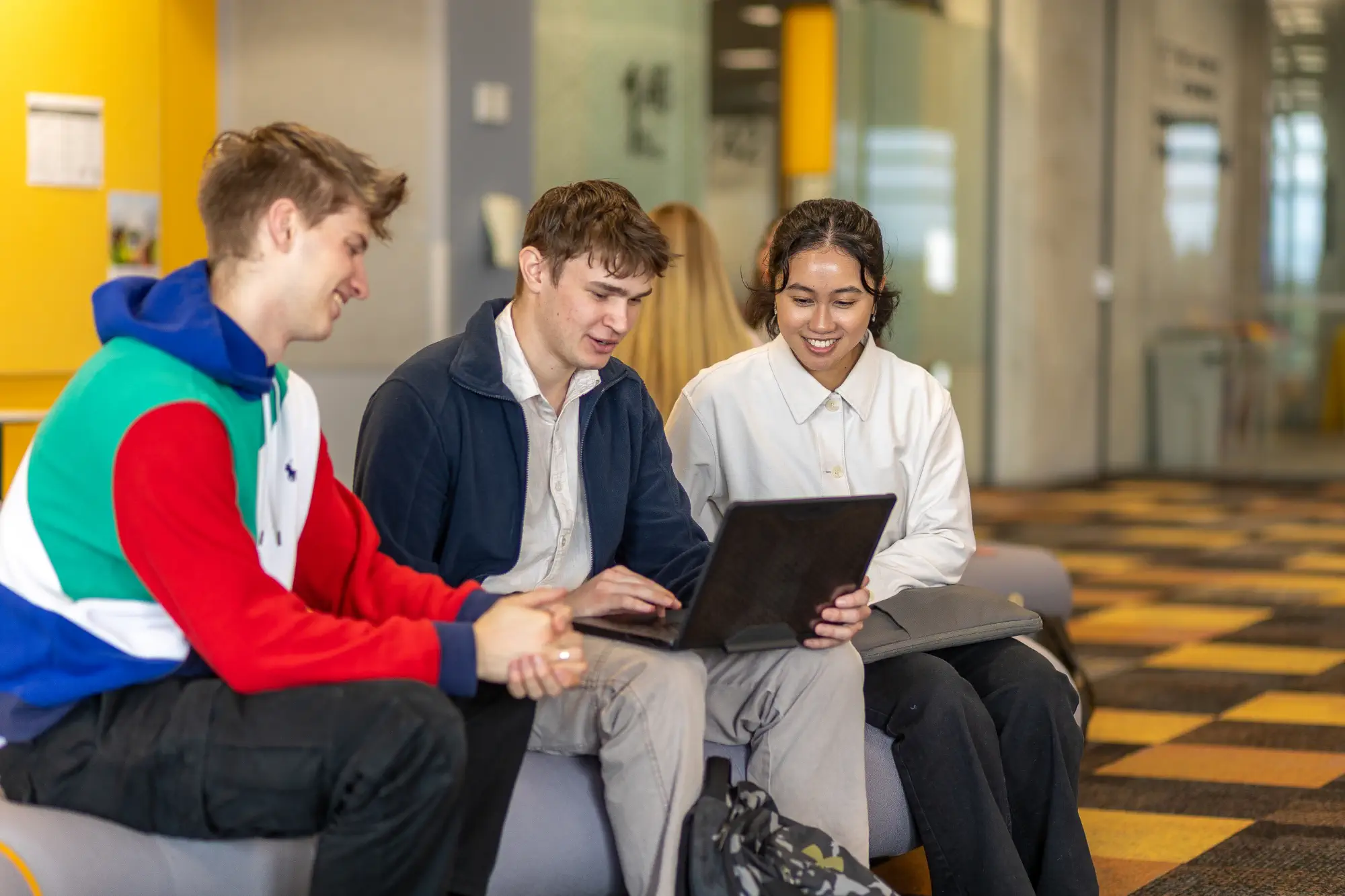 students-gathered-around-laptop-studying